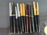 several pens are lined up in a row on a table