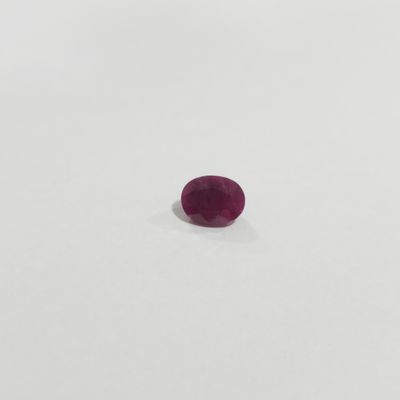a single ruby stone on a white surface