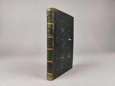 un livre noir aux bords dorés posé sur une table