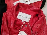 two red leather jackets with tags on them sitting on a table