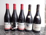six bouteilles de vin sont alignées sur une table
