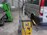 une camionnette garée dans un garage, avec une machine posée au sol