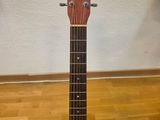 a close up of a guitar on a stand on a wooden floor