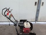an image of a small lawn mower parked in front of a building