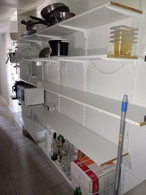 des étagères sur lesquelles sont posées des casseroles et des poêles dans une cuisine