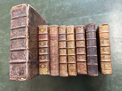 several old books stacked on top of each other on a table