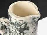 a black and white pitcher with a handle on a table