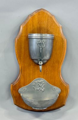 a wooden plaque with a silver cup on it