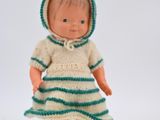 a doll that is wearing a green and white dress