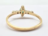 a close up of a gold ring with a green stone