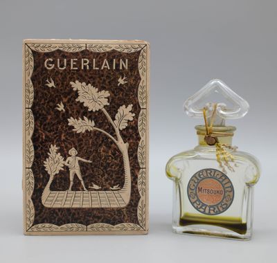 a small bottle of perfume sitting next to a box