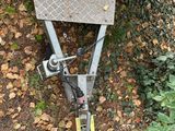 a small trailer with a pair of scissors on top of it
