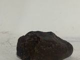 a rock that is sitting on the ground next to a wall