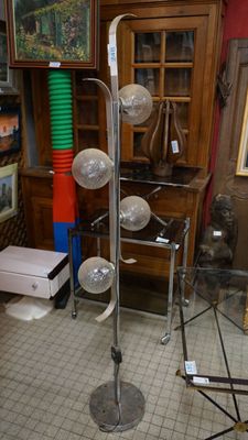 Un lampadaire en métal chromé biface muni de quatre lumières…