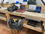 a workbench with tools and a laptop on it