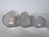 six empty glass cups sitting on a white surface