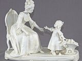 a figurine of a woman and a child sitting on a bench