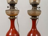 pair of red vases with flowers on them sitting on a table