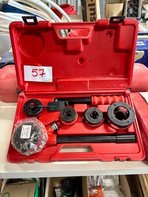 Quelqu'un tient une boîte à outils rouge contenant des outils.