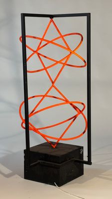 an orange wire sculpture on a black stand with a white background