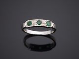 une bague en or blanc sertie d'émeraudes et de diamants