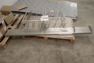 un tas de barres d'acier posées sur une palette dans un entrepôt