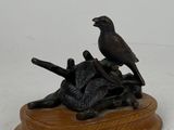 une statue représentant un oiseau perché sur une souche d'arbre