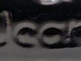 a close up of a black and white vase with a word written on it