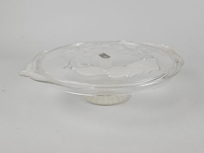 une photo d'un plat à gâteau en verre transparent posé sur une surface blanche