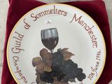 une assiette sur laquelle sont disposés un verre à vin et des raisins