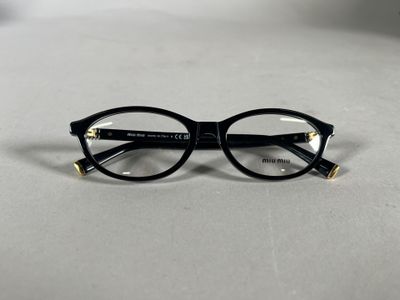 des lunettes noires aux verres transparents posées sur une surface blanche