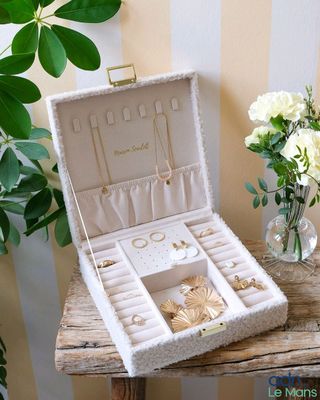 a small wooden table with a jewelry box and vase of flowers