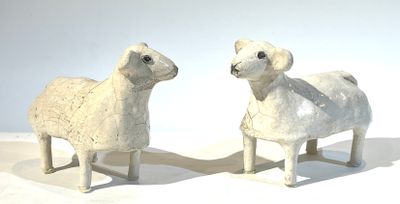 deux moutons blancs debout l'un à côté de l'autre sur une surface blanche