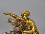 a statue of a man riding a horse with a woman on it