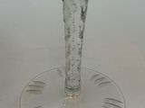 a glass vase with a flower in it sitting on a table