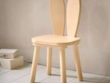 une chaise en bois sur laquelle sont fixées deux oreilles de lapin