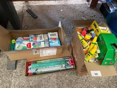 deux cartons de fournitures scolaires posés par terre l'un à côté de l'autre