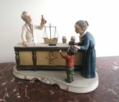 a figurine of a woman and a boy with a scale on a table