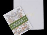 a close up of a white card with a green ribbon on it