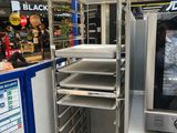 un four argenté installé à l'intérieur d'un magasin, à côté d'un comptoir