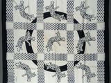 an image of a black and white quilt with a picture of a cat