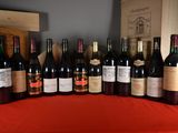 bottles of wine are lined up on a table with a red table cloth