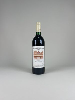 une bouteille de vin rouge posée sur une table blanche