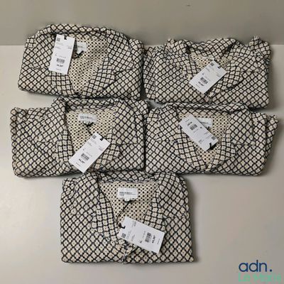 quatre sacs noirs et blancs, munis d'étiquettes, posés sur une table