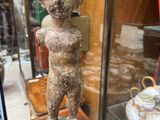 a statue of a man on a table in front of a glass case