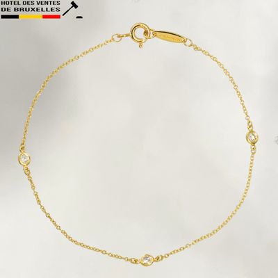 a close up of a gold bracelet with diamonds on a white background