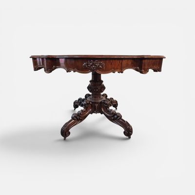 une table ancienne aux pieds sculptés et au plateau en bois