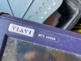 a purple electronic device sitting on top of a pile of assorted items
