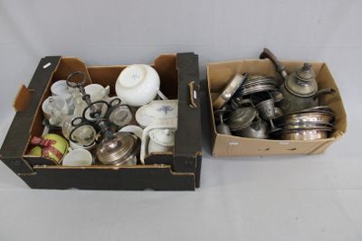 two boxes with silver items in them on a white surface