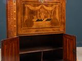 an antique wooden cabinet with a painting on the door